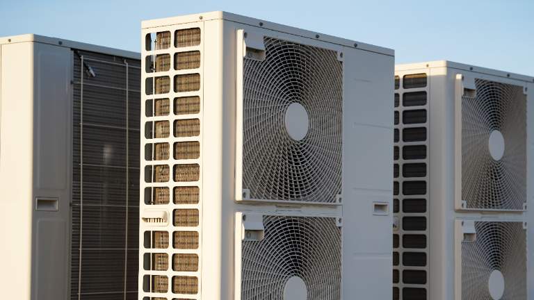 Modern air source heat pump unit installed outside a school building